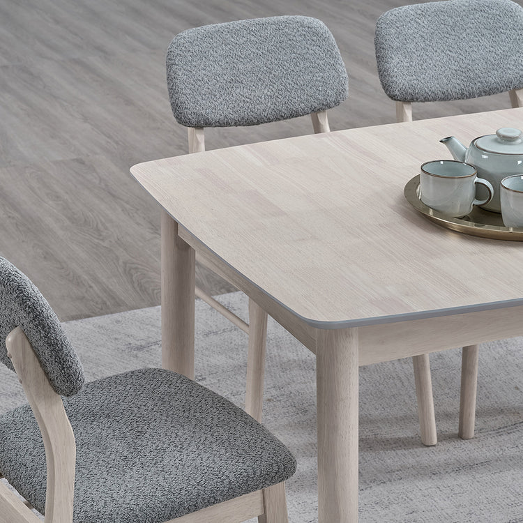 ACTU 826 Double-Extension Butterfly Dining Table; White Wash; close-up of rounded tabletop corner and upholstered chairs; chairs not included